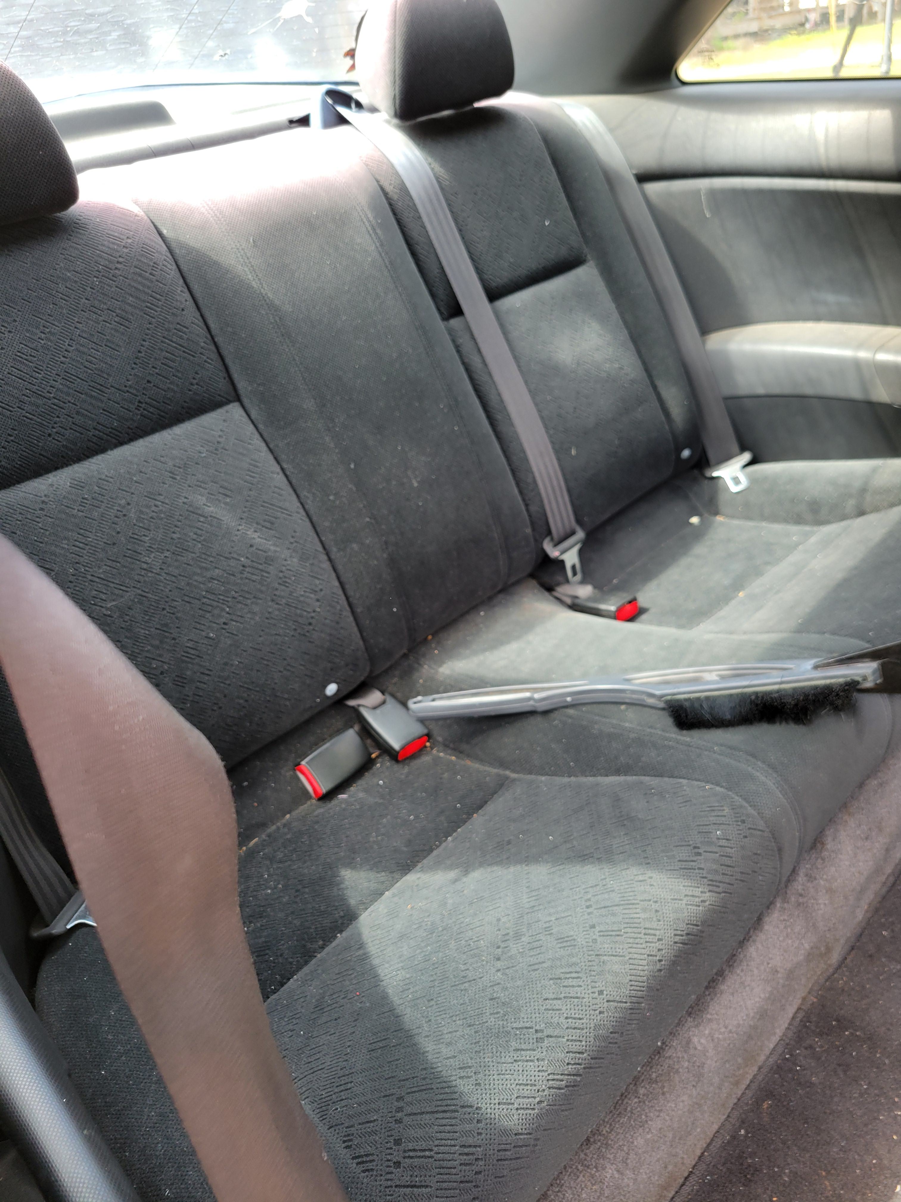 Dirty cloth seats in a car before professional cleaning.