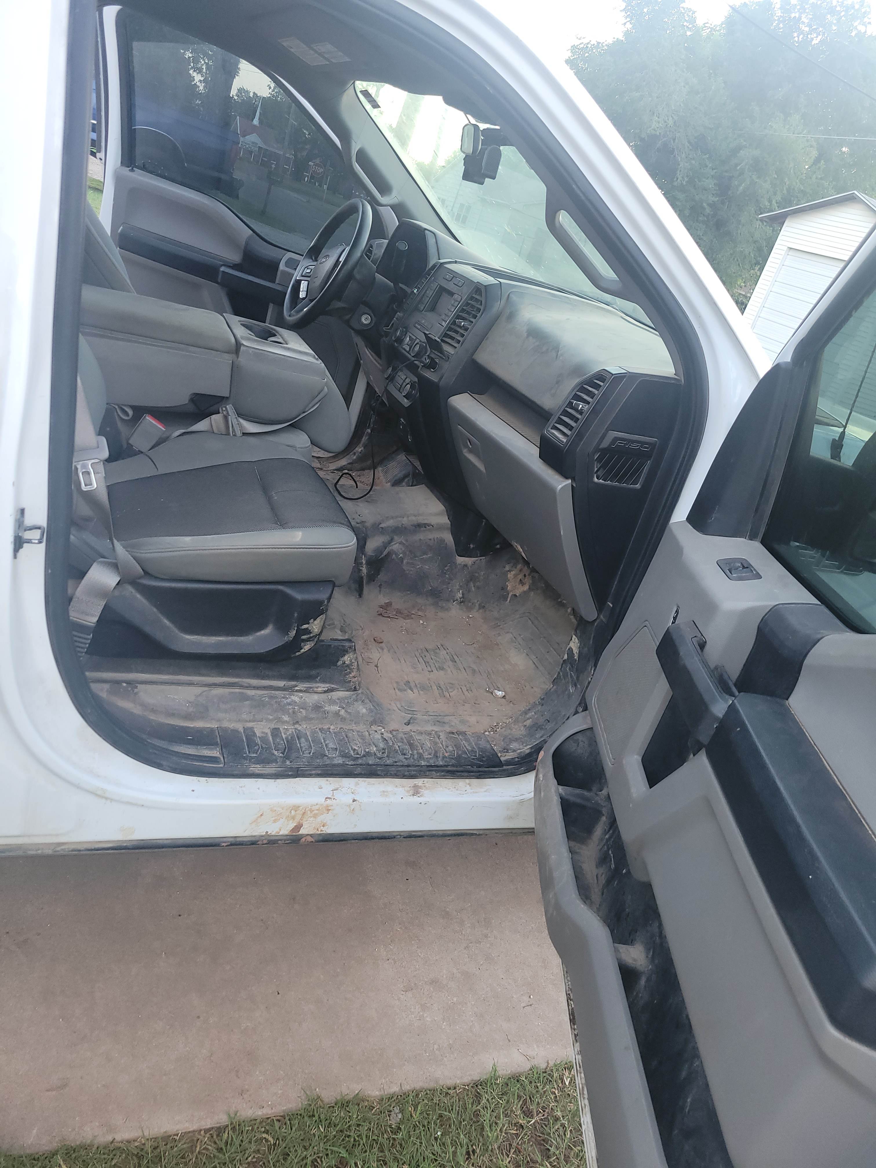Work truck interior before detailing, covered in mud and dirt.