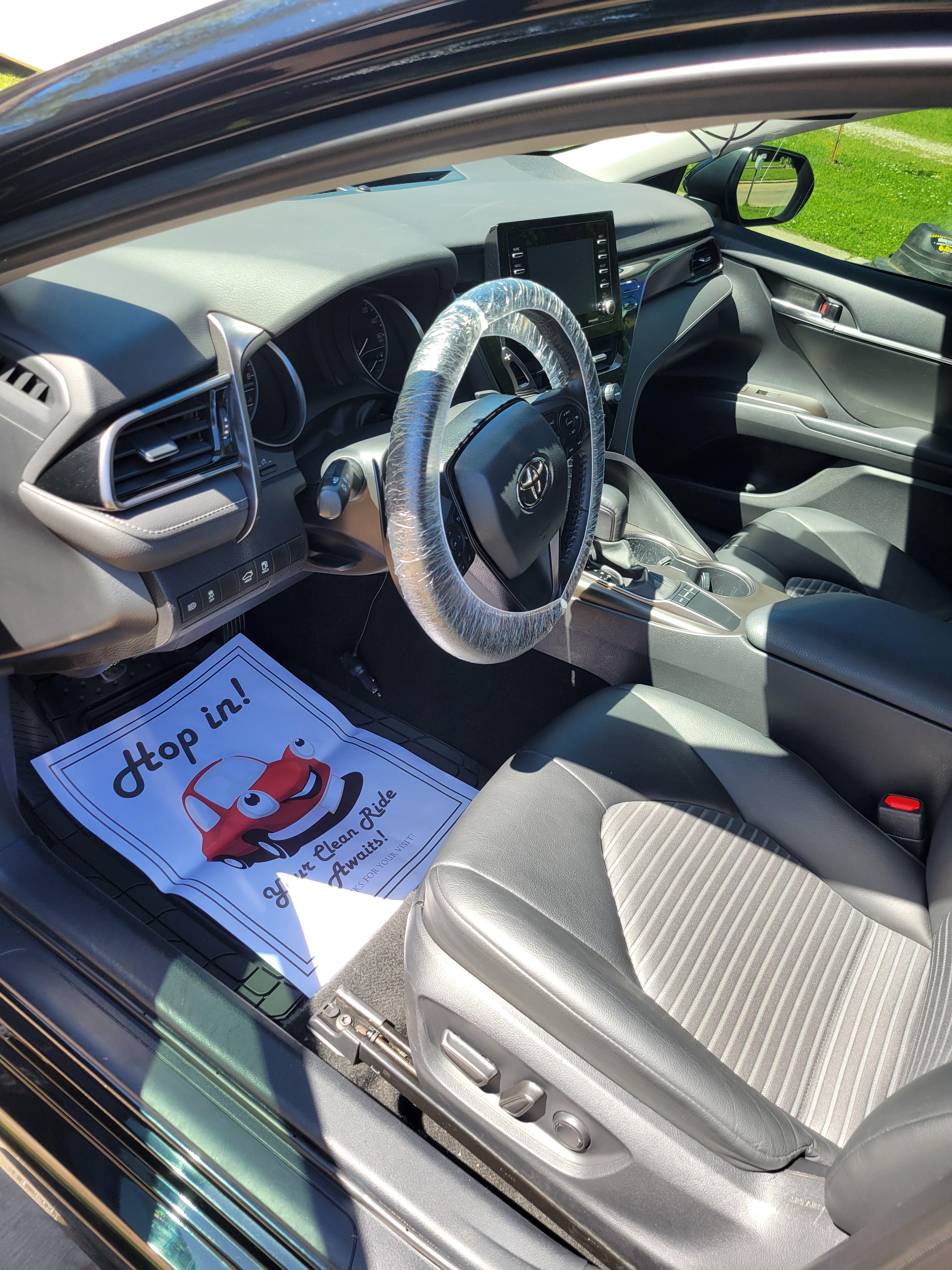 Clean interior of a Toyota Camry with protective steering wheel cover.
